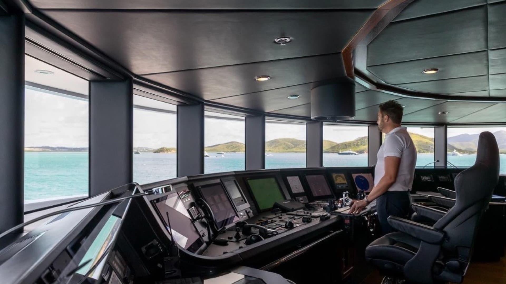 Modern luxury yacht bridge with integrated navigation displays and helm controls overlooking open water — inspection readiness starts with organised, verified crew documentation