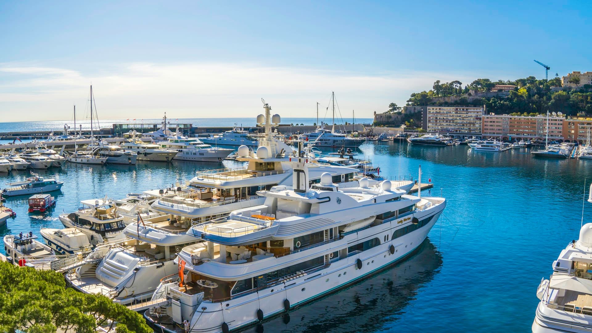 Luxury yachts docked in a Mediterranean marina — fleet compliance spans every vessel and crew member