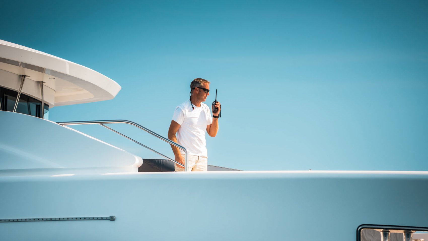 Male,Superyacht,Deckhand,With,A,Handheld,Radio,Getting,Ready,To
